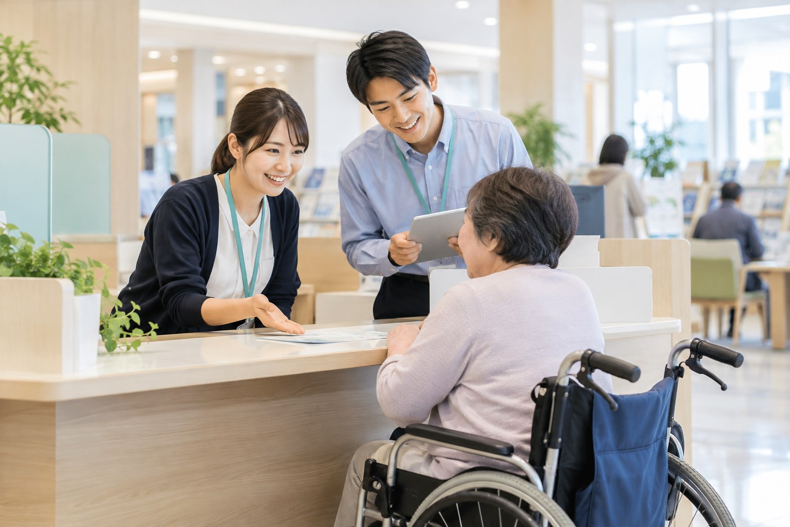 公共施設の窓口で、車いすを利用する人に案内する二人の担当者
