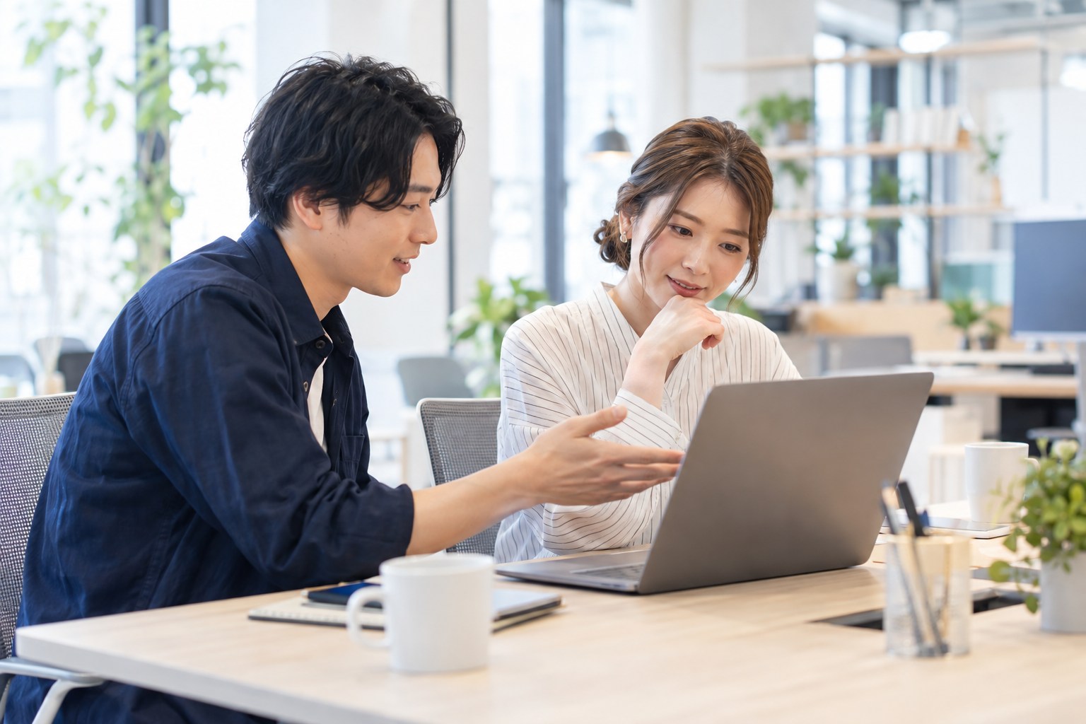 ノートパソコンを見ながら、利用する場面を相談する二人