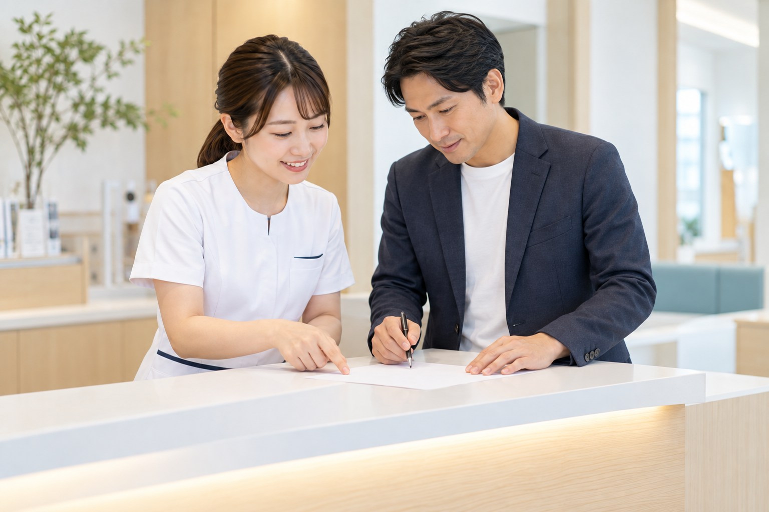 受付の内側で、案内資料を公開前に確認する担当者