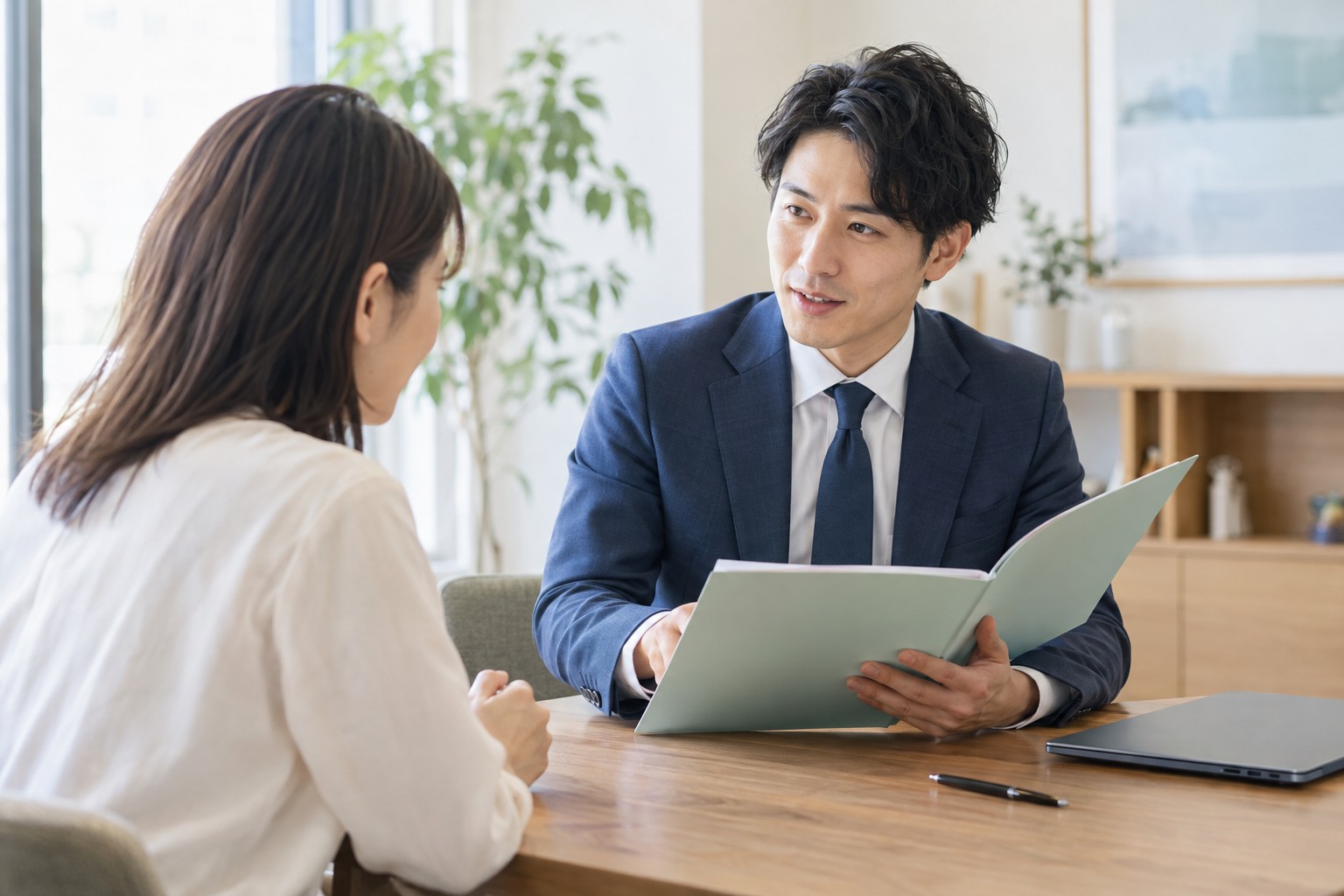 机上の資料を整理し、相談内容を確認する若い専門家